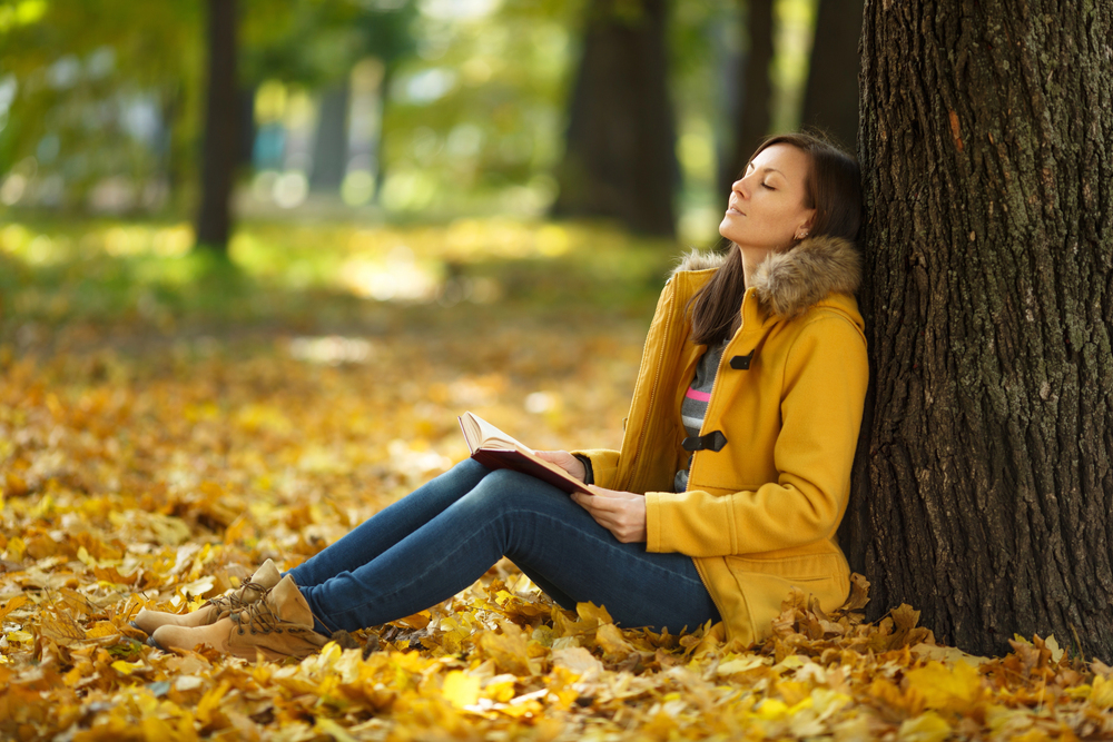 Frau mit Buch in der Natur